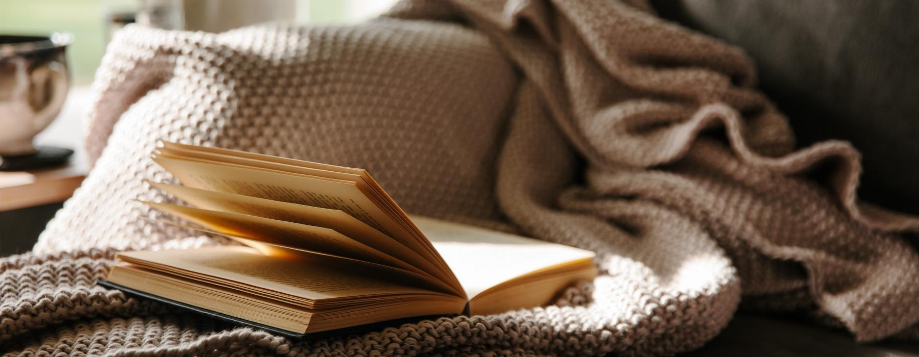 a couch with a book on a blanket