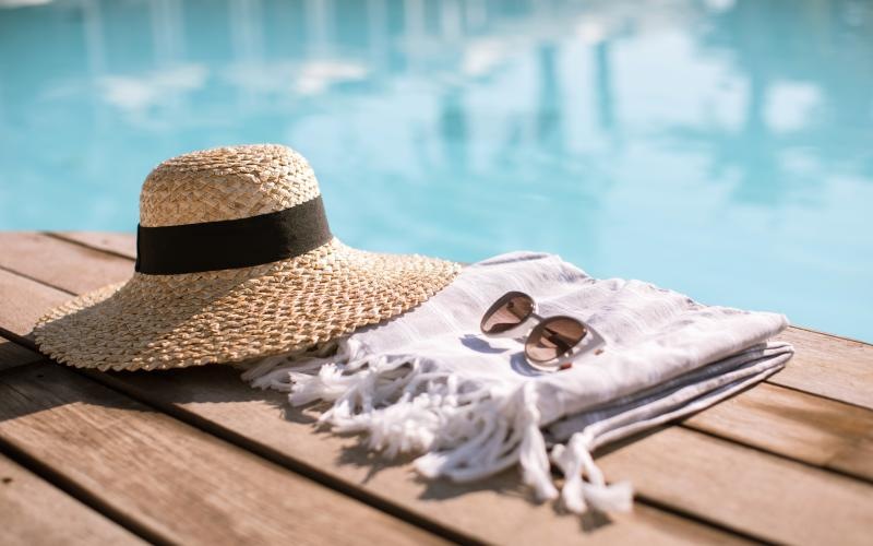 a hat and sunglasses by a pool