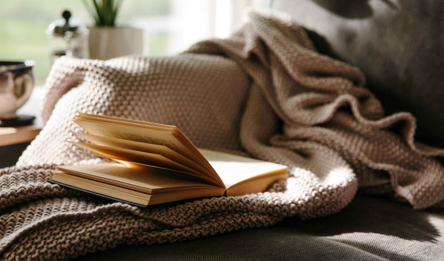 a couch with a book on a blanket